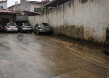 Impermeabilização do quintal pode desviar chuva e agravar danos no muro vizinho.