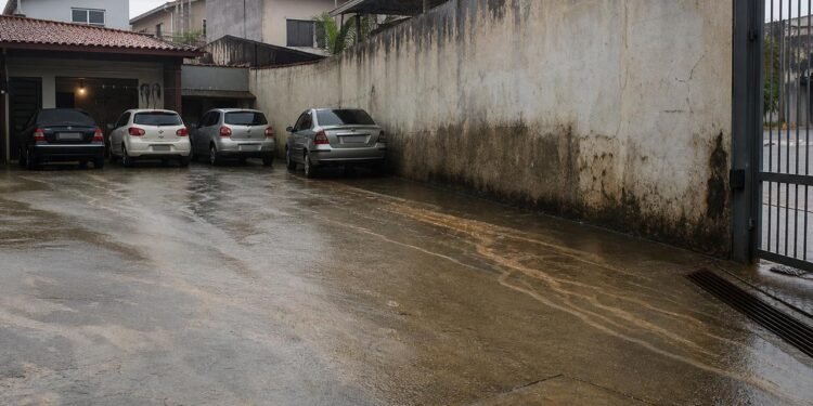 Impermeabilização do quintal pode desviar chuva e agravar danos no muro vizinho.