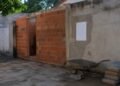 Edícula pela metade colada no muro do quintal, com aviso de embargo