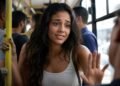Passageira com expressão de quem se desculpa dentro de um ônibus lotado