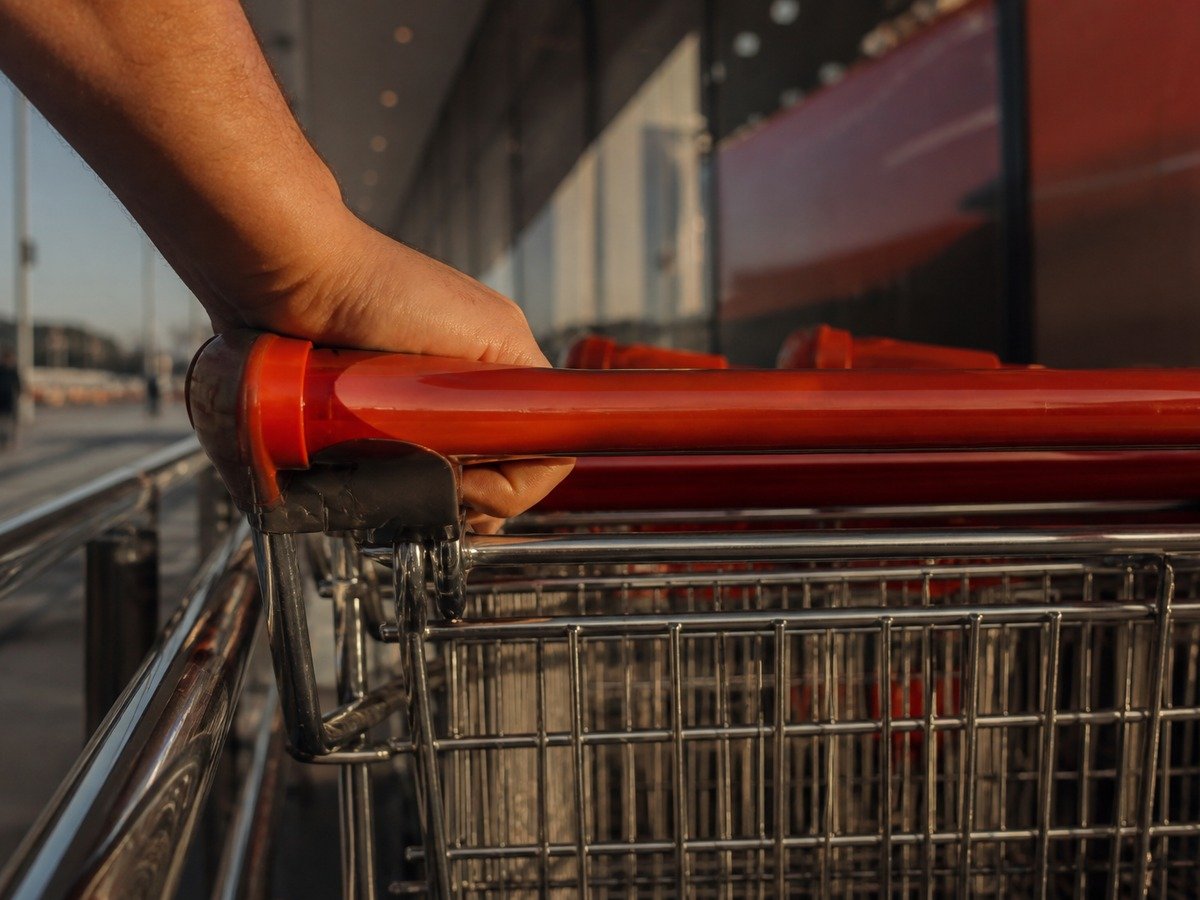 Mão encaixa o carrinho no bagageiro junto dos outros