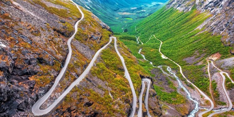 Com onze curvas fechadas esculpidas na montanha e inclinação de 9%, a estrada de Trollstigen na Noruega desafia motoristas sob neblina