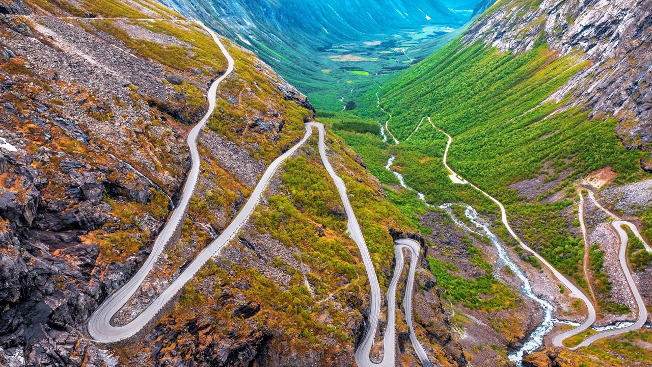 Com onze curvas fechadas esculpidas na montanha e inclinação de 9%, a estrada de Trollstigen na Noruega desafia motoristas sob neblina