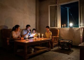 Família utiliza velas e um pequeno gerador para iluminar a casa durante a noite e descobre que sua propriedade aparece como atendida por um programa de eletrificação rural; registros indicam a instalação de postes e ligações que os moradores afirmam nunca ter recebido