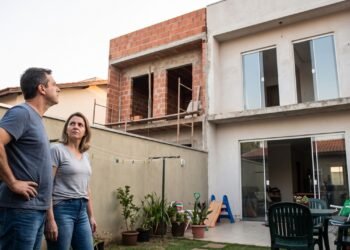 Vizinho constrói um segundo andar com janelas voltadas diretamente para o quintal de uma família e a obra reduz a privacidade da casa; os proprietários procuram saber se podem exigir alterações na construção