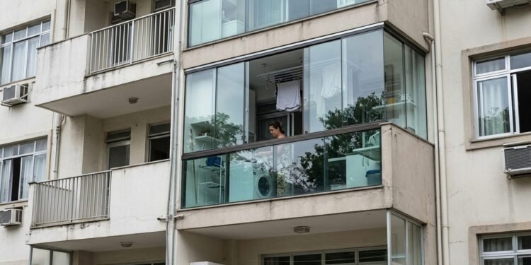 Moradora fecha a área de serviço do apartamento com vidro para evitar a entrada de chuva e, após uma reclamação anônima, recebe notificação do condomínio para desfazer a alteração
