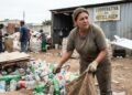 Catadora trabalha dez horas por dia separando materiais recicláveis e descobre que uma cooperativa aparece em relatórios municipais como beneficiária de R$ 870 mil em equipamentos e serviços; os trabalhadores afirmam que continuam utilizando ferramentas improvisadas e nunca receberam as máquinas previstas