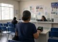 Sala de atendimento de assistência social com balcão e leitor biométrico
