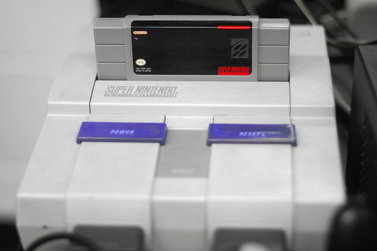 Super Nintendo com o cartucho do Super Mario World encaixado